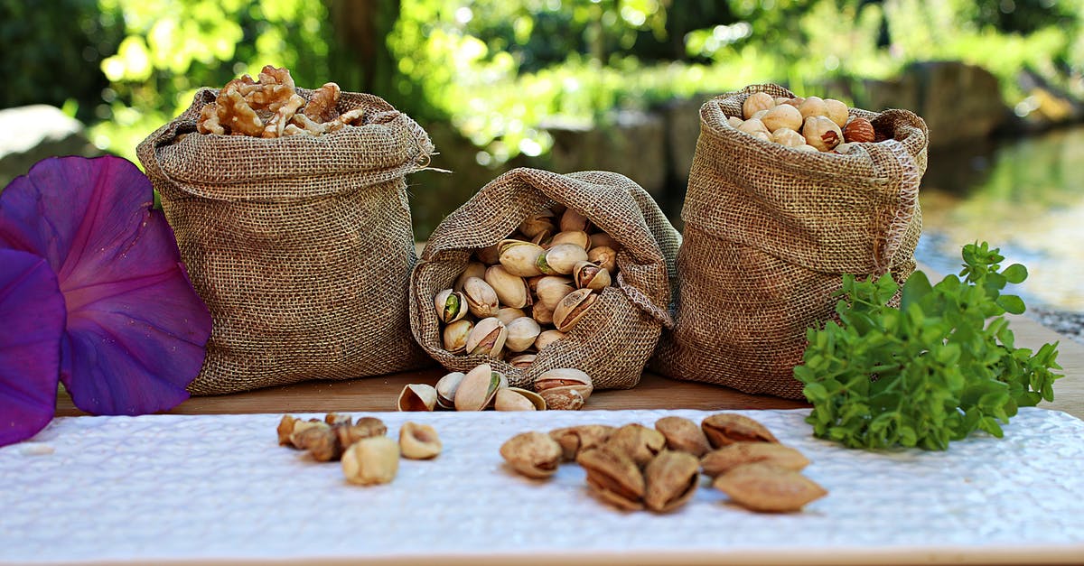 Travelling to Asia and Oceania with a peanut and pistachio allergy - Jute sacks with pistachios walnuts and peanuts placed on wooden table in park near pond on sunny day Travelling to Asia and Oceania with a peanut and pistachio allergy - Jute sacks with pistachios walnuts and peanuts placed on wooden table in park near pond on sunny day