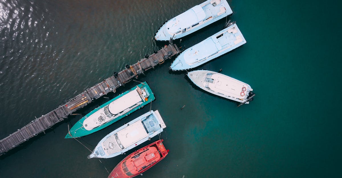 Travelling to Berlin and taking a cruise from Rostock halting at Norwegian Ports - Boats moored near wooden quay in sea Travelling to Berlin and taking a cruise from Rostock halting at Norwegian Ports - Boats moored near wooden quay in sea