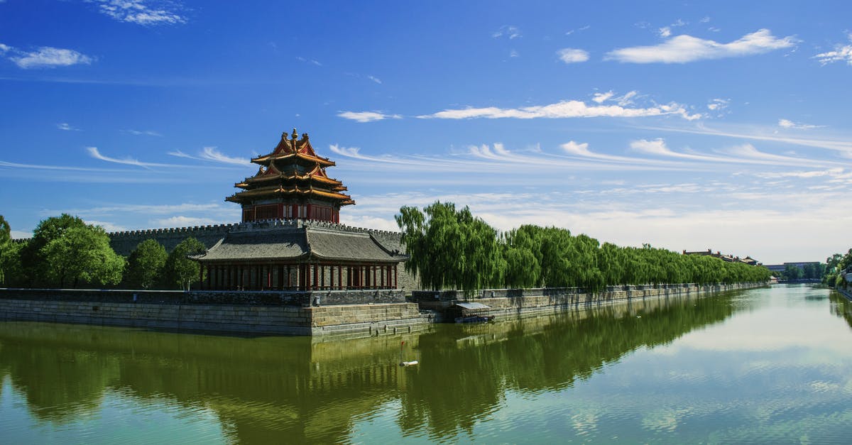 Travelling to China - Concrete Temple Near Body of Water Under Blue Sunny Sky Travelling to China - Concrete Temple Near Body of Water Under Blue Sunny Sky