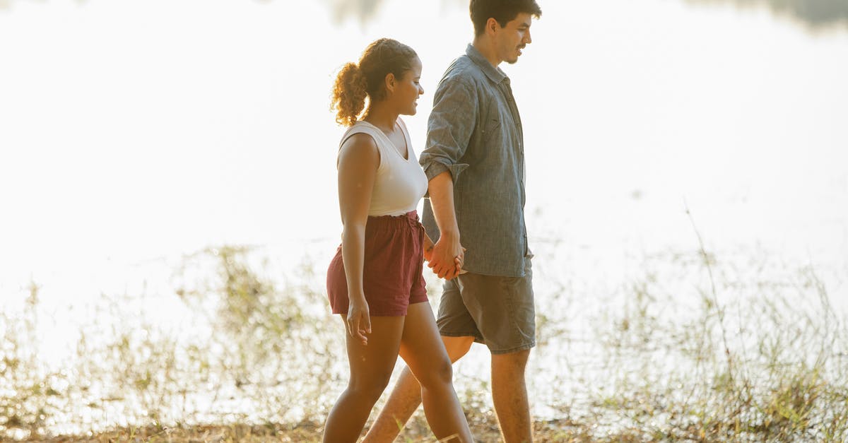 Travelling to Phillipines before valid on date in Schengen visa [closed] - Loving young multiethnic couple holding hands while hiking on lake shore