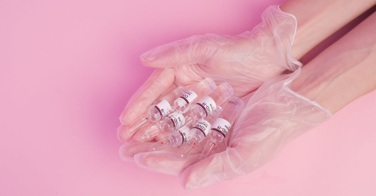 Travelling to Romania by train from Austria - COVID-19 quarantine risk at the border? [duplicate] - Anonymous woman demonstrating COVID 19 vaccine ampules in hands
