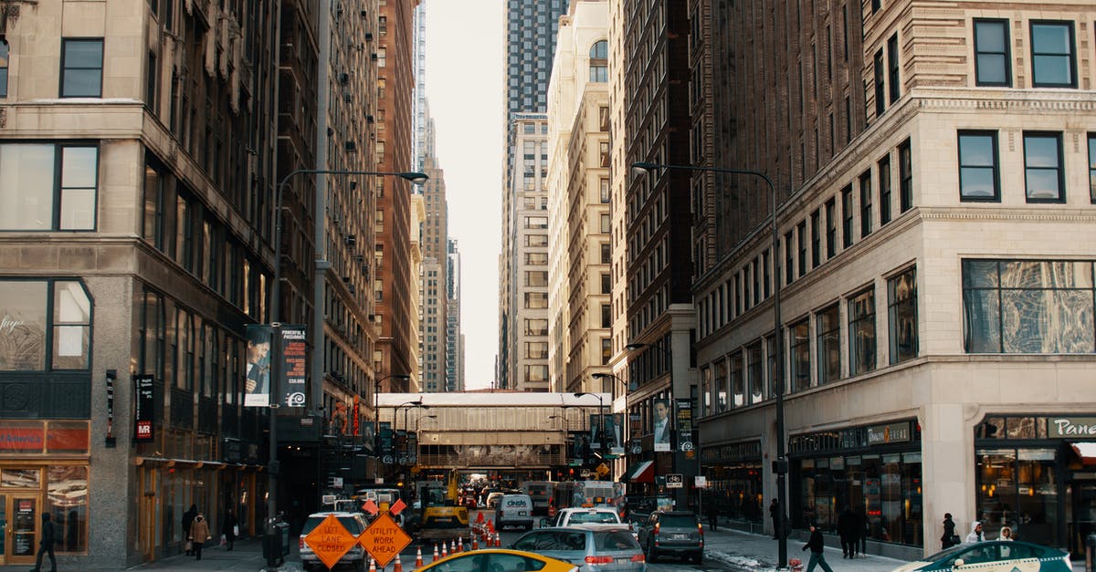 Travelling to rural areas in the US without a car - Cars driving on asphalt road between contemporary skyscrapers and buildings in New York City in daytime Travelling to rural areas in the US without a car - Cars driving on asphalt road between contemporary skyscrapers and buildings in New York City in daytime