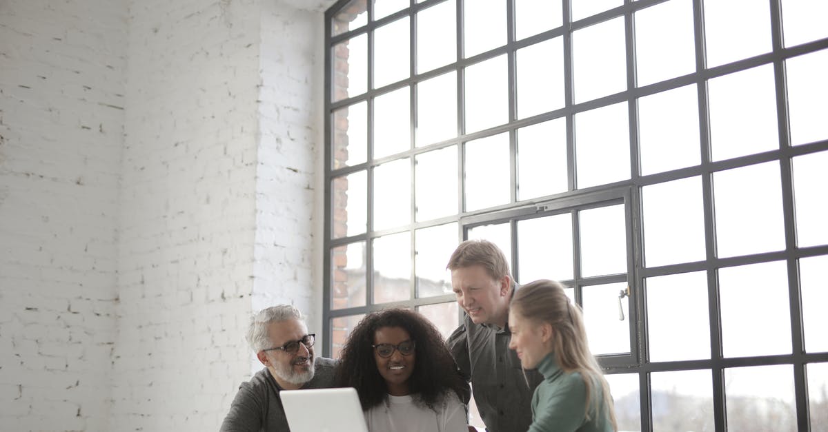 Travelling to US using B1/B2 visa annotation "B1 IN LIEU OF H" to different company - Cheerful diverse colleagues of different ages working on laptop during startup project