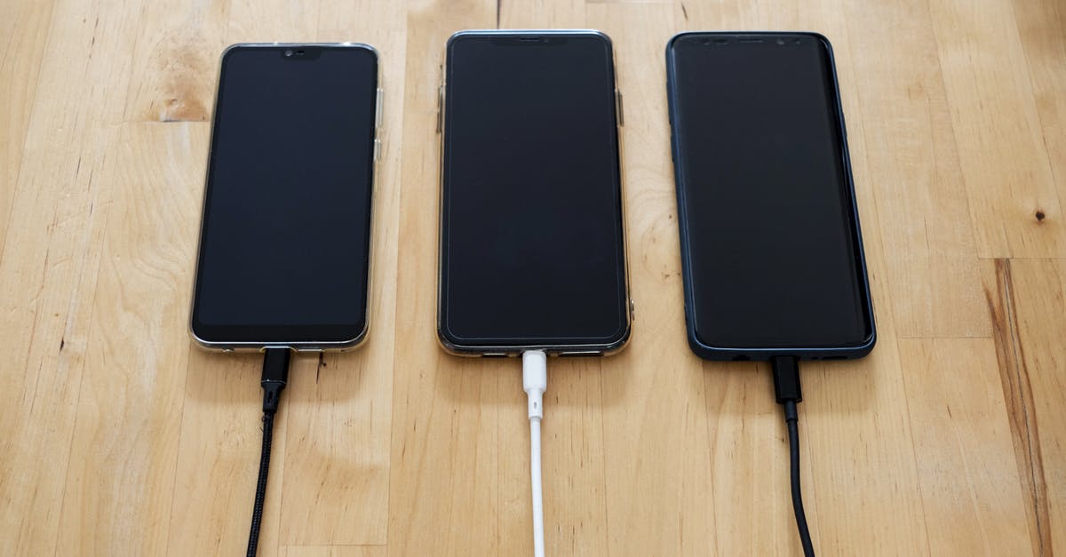Travelling with mobile phones with discharged batteries - Black Android Smartphones on Brown Wooden Surface Travelling with mobile phones with discharged batteries - Black Android Smartphones on Brown Wooden Surface