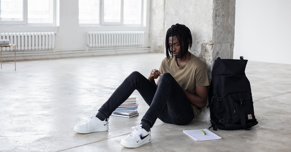 Trouble regarding Booking Tickets - Full body of upset African American man sitting among textbooks and notebook near backpack during break in exam preparation Trouble regarding Booking Tickets - Full body of upset African American man sitting among textbooks and notebook near backpack during break in exam preparation