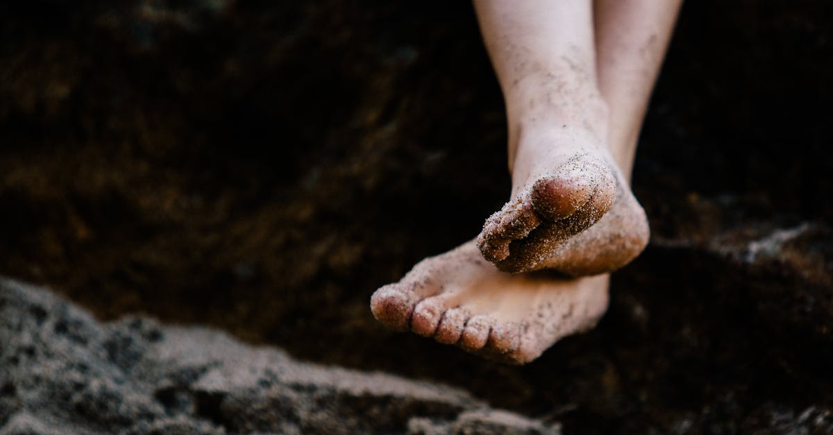 Trying to cross into Tijuana by foot without a passport? - Person With Crossed Legs Sitting on Rock Trying to cross into Tijuana by foot without a passport? - Person With Crossed Legs Sitting on Rock