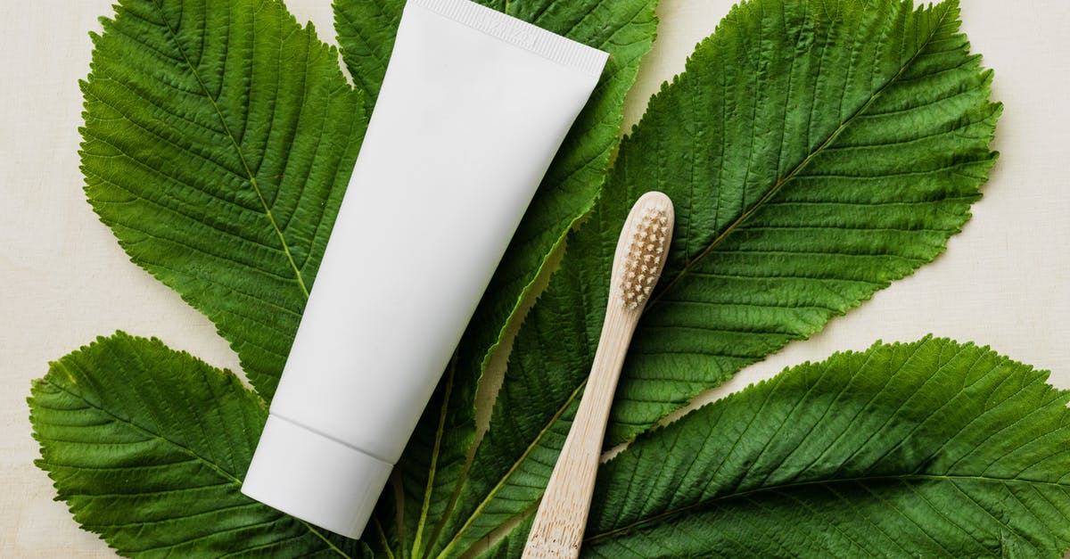 Tube from Heathrow to King's Cross - Top view of white mockup tube of natural toothpaste and eco friendly bamboo toothbrush placed flat on big green chestnut leaf on light wooden surface Tube from Heathrow to King's Cross - Top view of white mockup tube of natural toothpaste and eco friendly bamboo toothbrush placed flat on big green chestnut leaf on light wooden surface