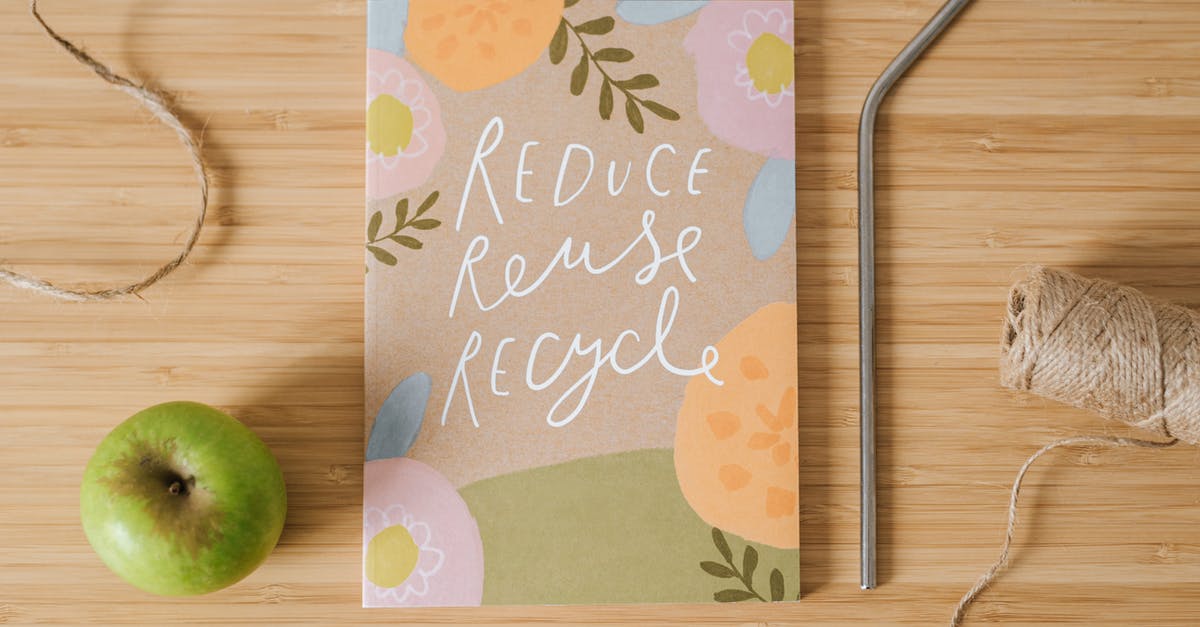 Tube from Heathrow to King's Cross - Top view of book with Reduce Reuse Recycle inscriptions near green apple and bobbin of thread on table Tube from Heathrow to King's Cross - Top view of book with Reduce Reuse Recycle inscriptions near green apple and bobbin of thread on table