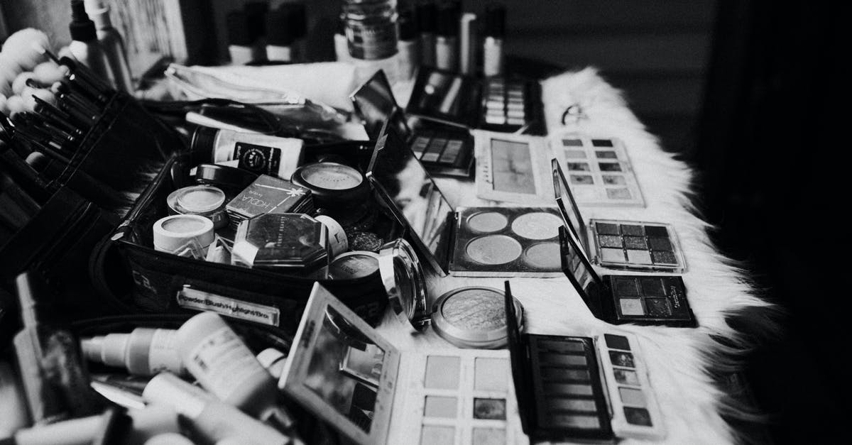 Tube from Heathrow to King's Cross - Black and white high angle of assorted makeup products and tools placed on dressing table near mirror Tube from Heathrow to King's Cross - Black and white high angle of assorted makeup products and tools placed on dressing table near mirror