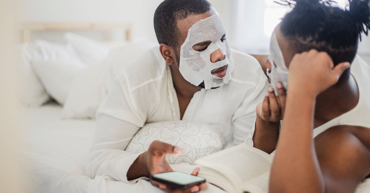Two passports, two different names, booked a flight - Two Men in Bedroom with Cosmetic Masks on Faces Two passports, two different names, booked a flight - Two Men in Bedroom with Cosmetic Masks on Faces