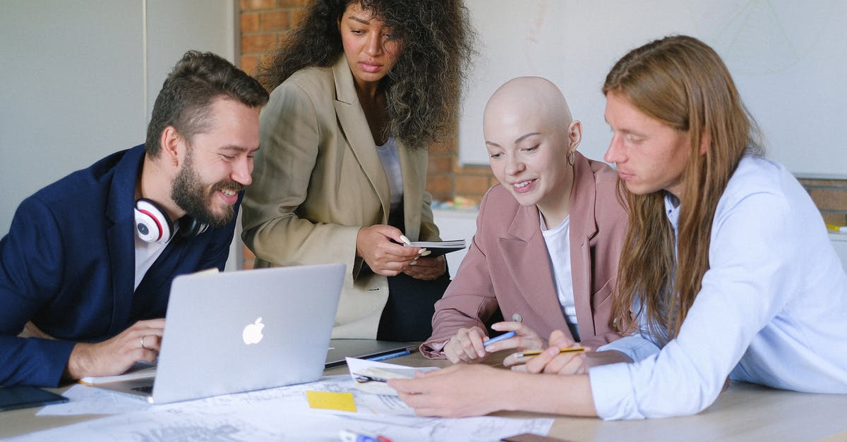 UK conference speaking: what if it's my job? - Group of glad multiracial businesspeople working with laptop at table UK conference speaking: what if it's my job? - Group of glad multiracial businesspeople working with laptop at table
