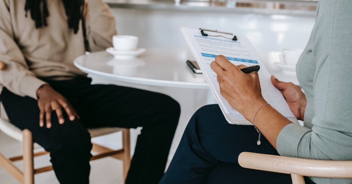 UK Immigration officers arrivals interview questions - Crop faceless multiethnic interviewer and job seeker going through interview UK Immigration officers arrivals interview questions - Crop faceless multiethnic interviewer and job seeker going through interview