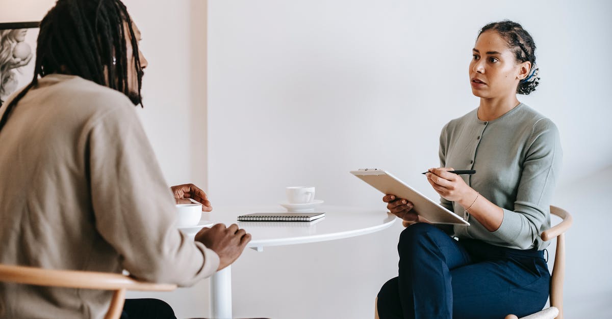 UK Immigration officers arrivals interview questions - Ethnic female psychotherapist listening to black clients explanation UK Immigration officers arrivals interview questions - Ethnic female psychotherapist listening to black clients explanation