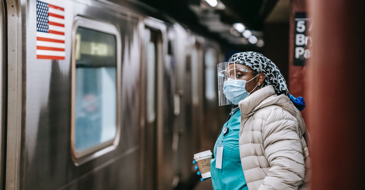 UK last train cancellation and unhelpful staff - what to do? - Nurse in protective mask and coat waiting for train on subway station UK last train cancellation and unhelpful staff - what to do? - Nurse in protective mask and coat waiting for train on subway station