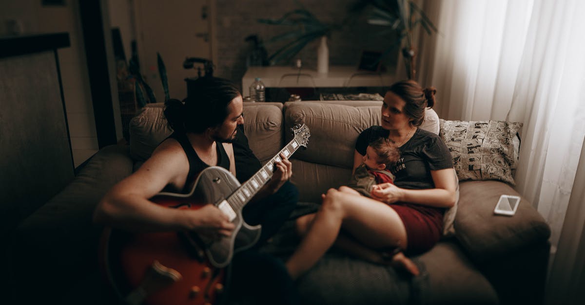 UK standard visit visa rejected from India for my wife and 2 kids - Ethnic man playing guitar near woman and son at home