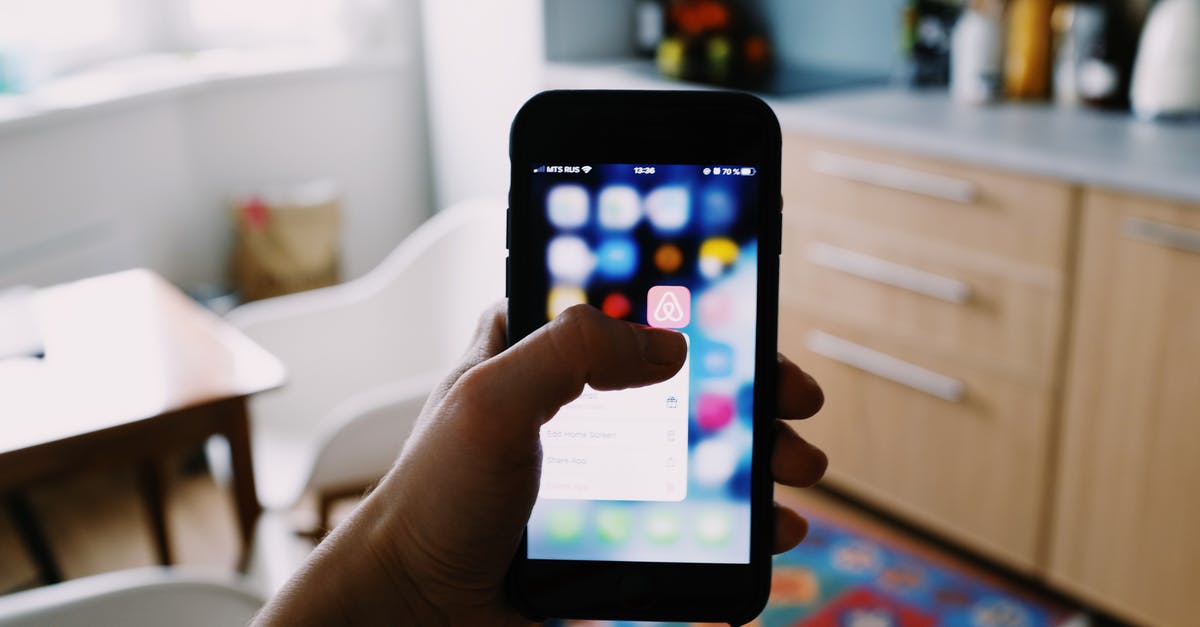 UK Standard Visitor Visa: how long does it take to get application acknowledgement? - From above of crop anonymous person touching blurred cellphone screen while opening app and choosing option from pop up window