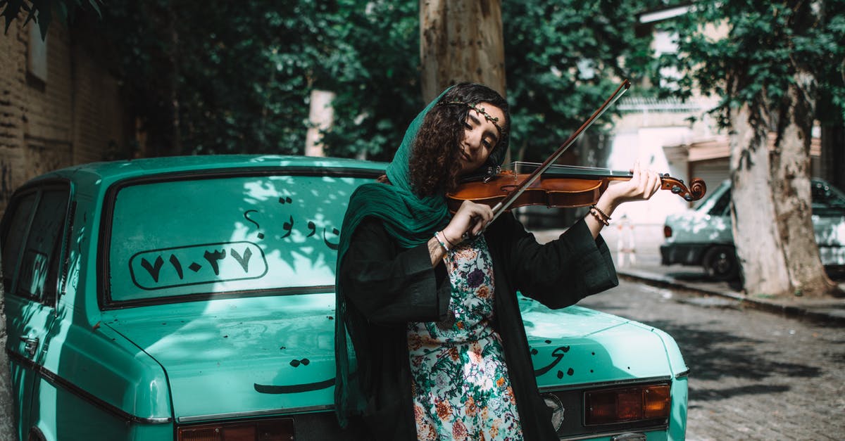 UK to Iran by car - insurance question - Woman Playing Violin While Leaning On Green Vehicle UK to Iran by car - insurance question - Woman Playing Violin While Leaning On Green Vehicle