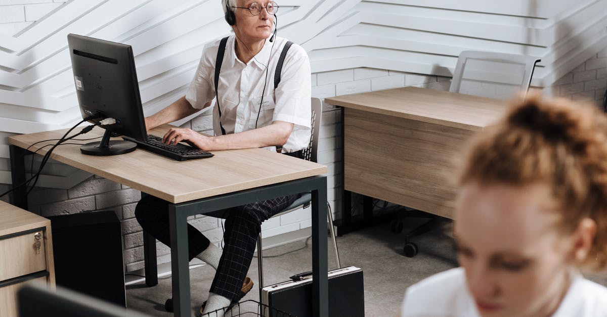 UK Visa Bronze Premium Service - Man in White Button Up Shirt Sitting Beside Brown Wooden Table UK Visa Bronze Premium Service - Man in White Button Up Shirt Sitting Beside Brown Wooden Table
