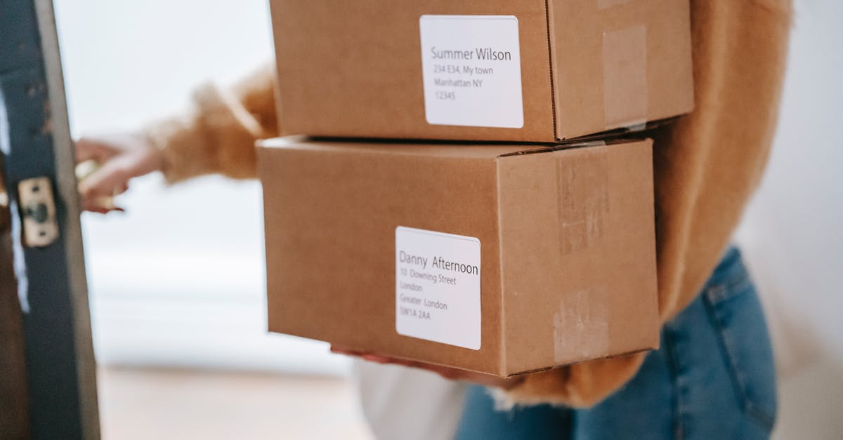 UK Visa Courier Address - Crop unrecognizable woman carrying boxes and entering post office UK Visa Courier Address - Crop unrecognizable woman carrying boxes and entering post office