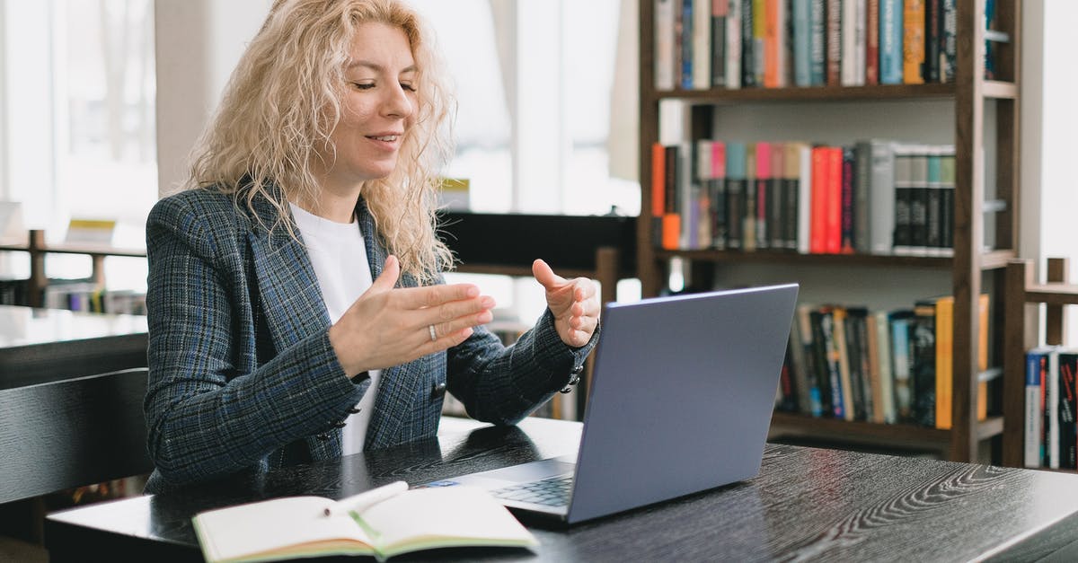 UK Visa for Freelancer Tuition Teacher - Smiling woman having video chat via laptop in library UK Visa for Freelancer Tuition Teacher - Smiling woman having video chat via laptop in library