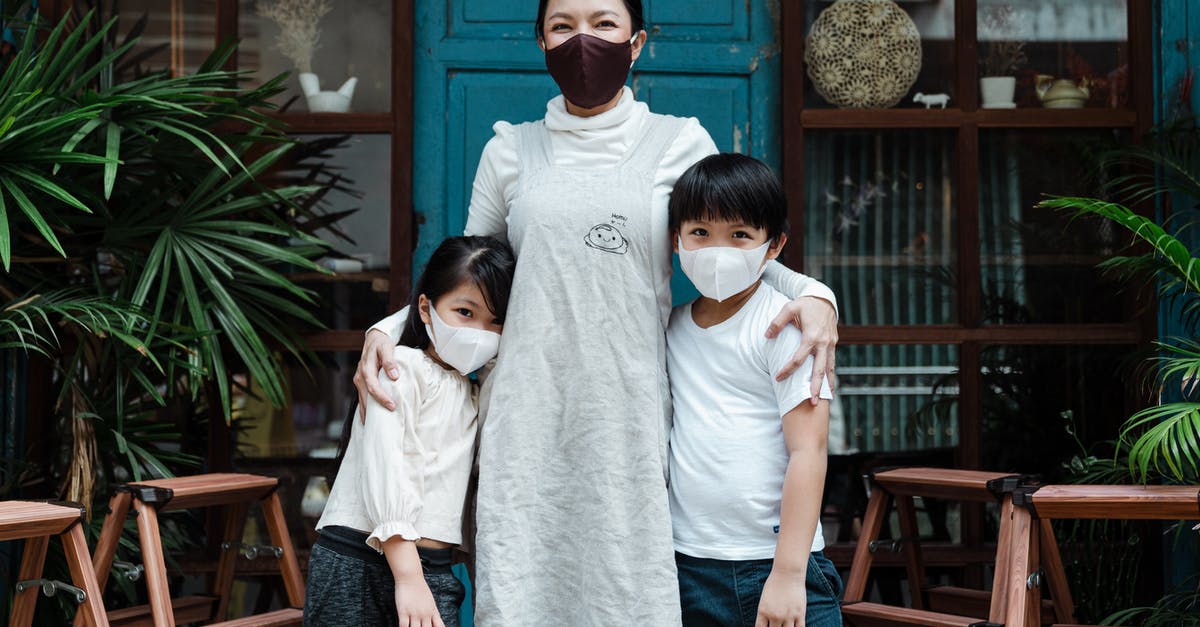 UK visa for my child refused as ECO could not be satisfied that their welfare would be taken care of (V4.11 V4.12) - Optimistic Asian woman embracing adorable son and daughter wearing casual clothes and medical protective masks while standing against rural weathered building and plants UK visa for my child refused as ECO could not be satisfied that their welfare would be taken care of (V4.11 V4.12) - Optimistic Asian woman embracing adorable son and daughter wearing casual clothes and medical protective masks while standing against rural weathered building and plants