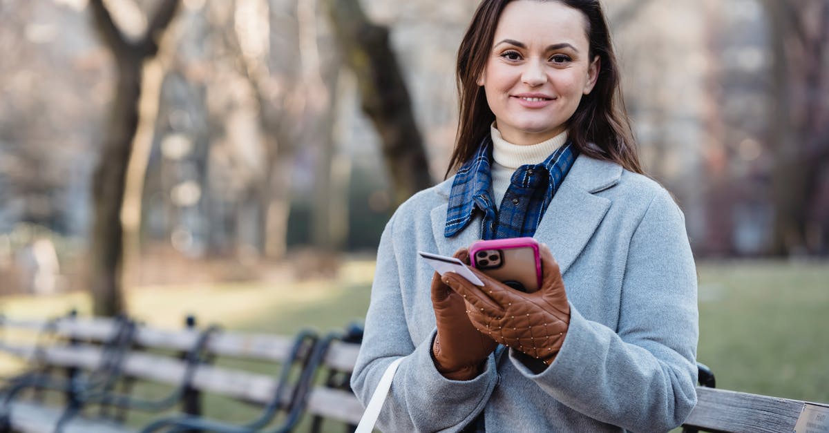 UK visa payment pending message - Smiling woman using smartphone on spring city park UK visa payment pending message - Smiling woman using smartphone on spring city park