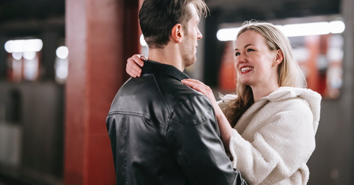 UK visa validity begins on date of issue or intended date of arrival? - Smiling couple looking at each other and embracing while standing on platform of metro with train on blurred background during date