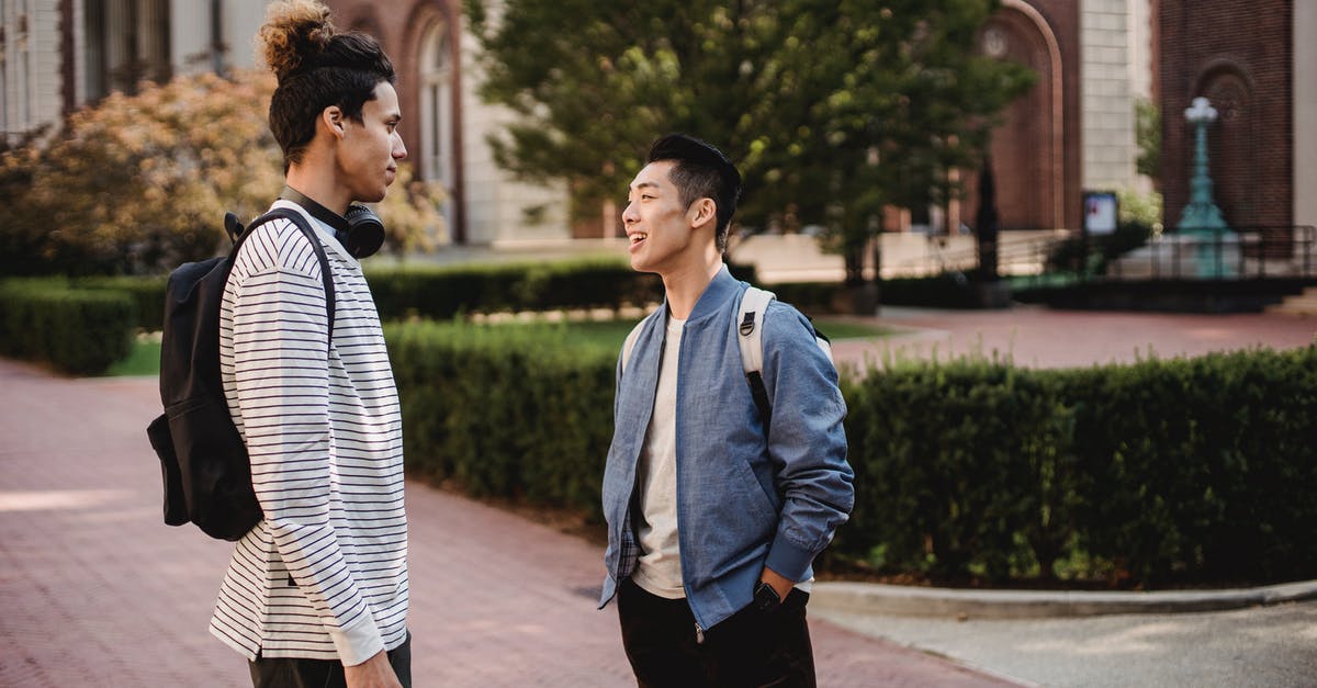 Uk visit Visa to meet sister,previously overstayed as a student in france - Content young multiethnic male friends wearing casual clothes standing on sidewalk and having conversation