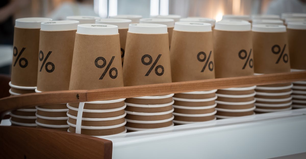 UK Visit Visas Refused Due to Evaluation Oversights and Similar Errors - Stack of similar disposable cups with printed percent sign placed on counter in modern coffee shop