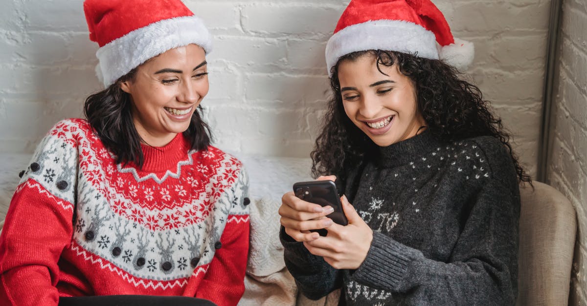 U.K. Youth mobility visa from Australian for 2 years expires - Positive ethnic girlfriends browsing smartphone during Christmas celebration U.K. Youth mobility visa from Australian for 2 years expires - Positive ethnic girlfriends browsing smartphone during Christmas celebration