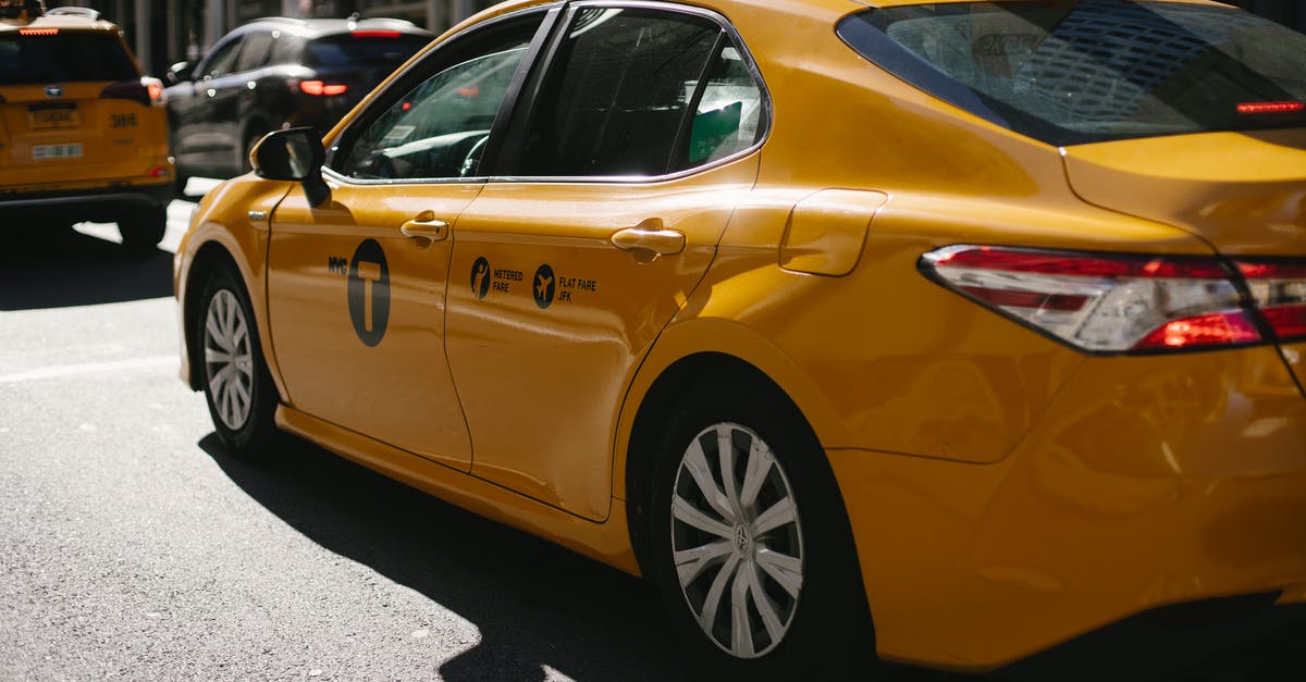 USA car rental one-way fee - Shiny yellow taxi driving along busy street in downtown USA car rental one-way fee - Shiny yellow taxi driving along busy street in downtown