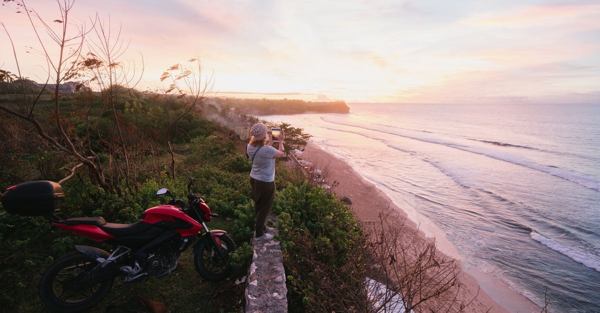 Use bike sharing service as a foreign tourist in China - Woman taking pictures of sunrise on tablet on green seashore Use bike sharing service as a foreign tourist in China - Woman taking pictures of sunrise on tablet on green seashore
