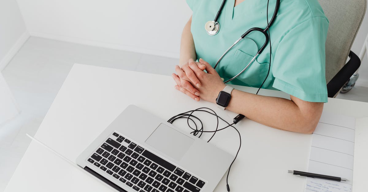 Using 2 Passports - Person in Teal Scrub Suit Using Macbook Pro Using 2 Passports - Person in Teal Scrub Suit Using Macbook Pro