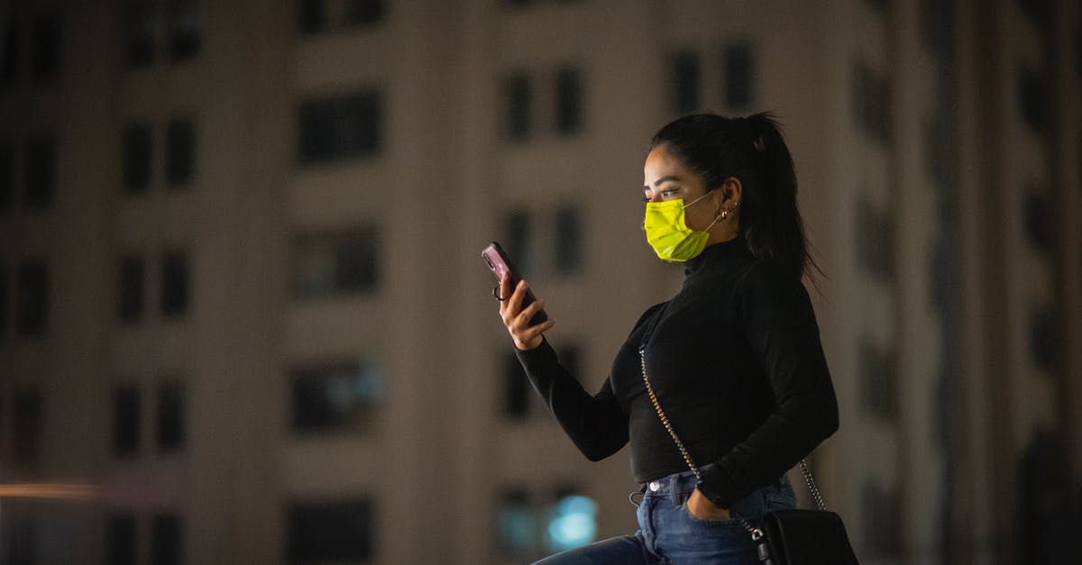 Using a quad-band phone in Japan? - Woman in a Mask Using Phone on a Street at Night Using a quad-band phone in Japan? - Woman in a Mask Using Phone on a Street at Night