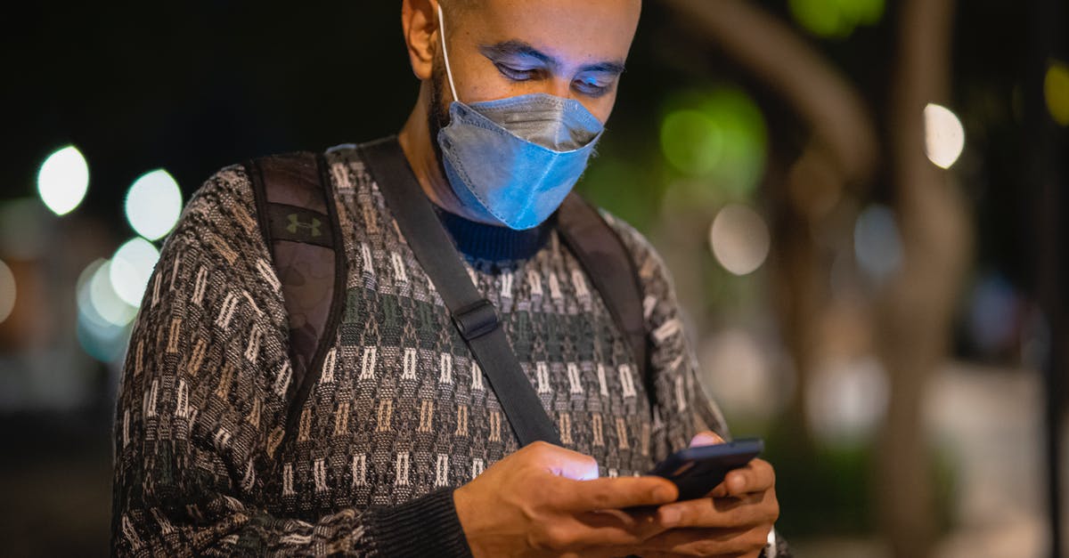 Using a quad-band phone in Japan? - Man with Mask Using a Phone in a Street at Night Using a quad-band phone in Japan? - Man with Mask Using a Phone in a Street at Night