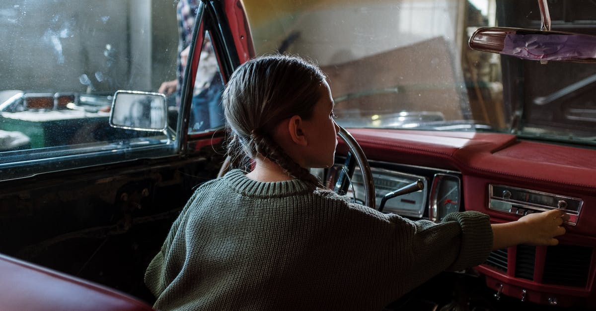 Using child car seats in Cuba? - Woman in White and Black Sweater Sitting Inside Car Using child car seats in Cuba? - Woman in White and Black Sweater Sitting Inside Car