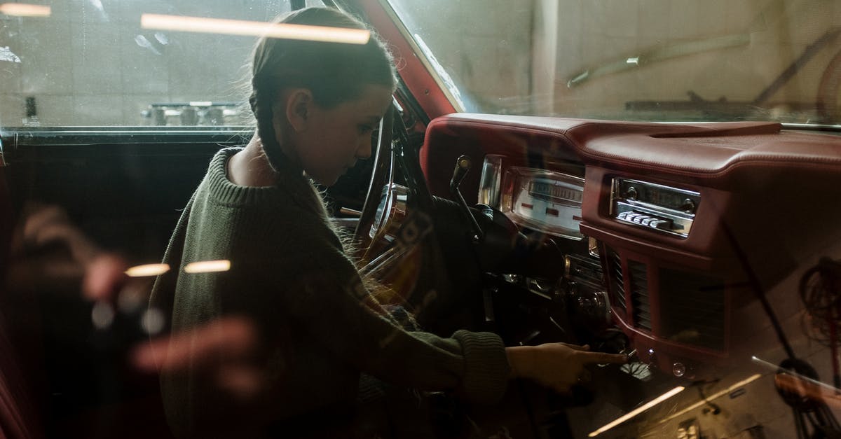 Using child car seats in Cuba? - Man in Black and White Striped Long Sleeve Shirt Sitting Beside Red Car Using child car seats in Cuba? - Man in Black and White Striped Long Sleeve Shirt Sitting Beside Red Car