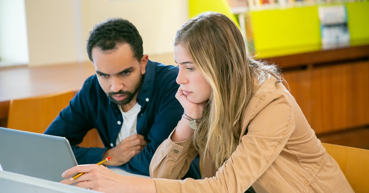 Using library in Frankfurt as a short-term visitor - Concentrated multiracial classmates using laptop for studies while doing homework assignment together in university Using library in Frankfurt as a short-term visitor - Concentrated multiracial classmates using laptop for studies while doing homework assignment together in university