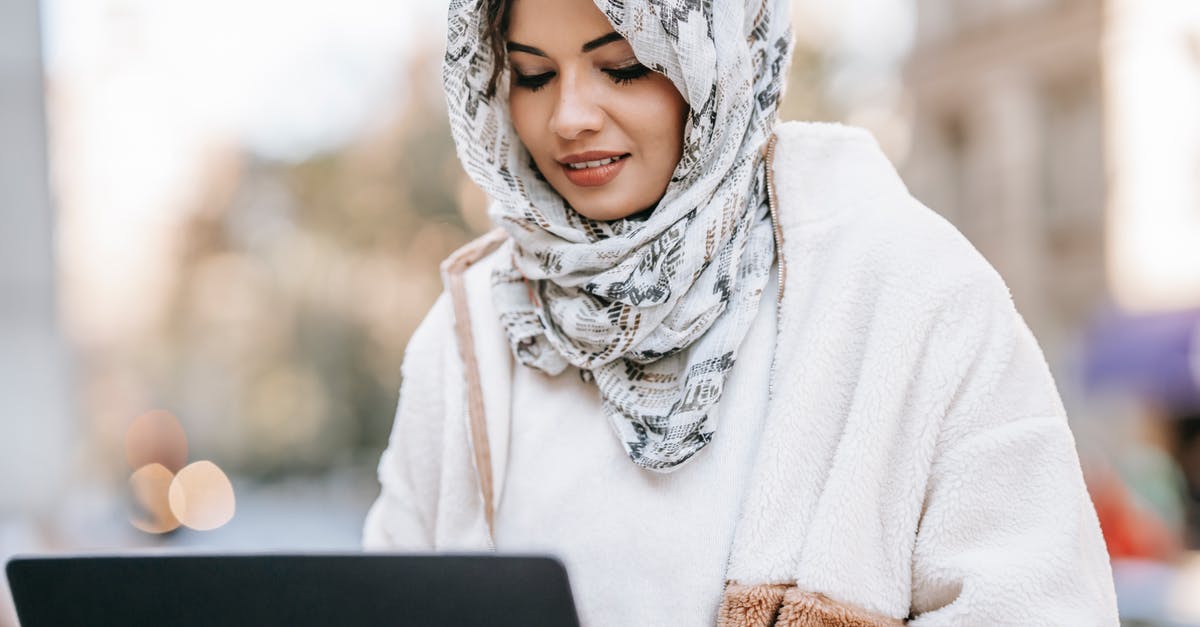Using Modern Standard Arabic in Arabic-speaking countries - Crop concentrated young ethnic woman in stylish outfit and elegant hijab sitting in street cafe and working remotely on laptop Using Modern Standard Arabic in Arabic-speaking countries - Crop concentrated young ethnic woman in stylish outfit and elegant hijab sitting in street cafe and working remotely on laptop