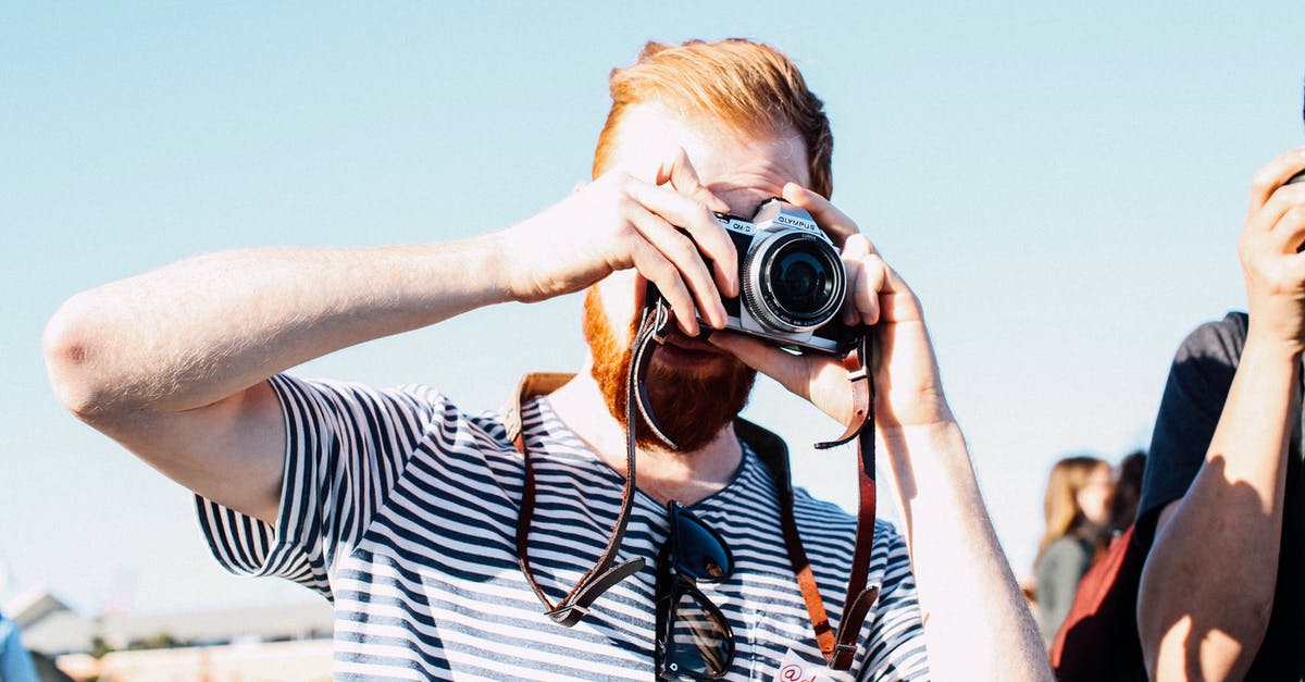 Using old 'full' passport for visa-free travel - Unrecognizable redhead bearded male photographer in casual outfit concentrating on taking picture by vintage photo camera on street event at daytime Using old 'full' passport for visa-free travel - Unrecognizable redhead bearded male photographer in casual outfit concentrating on taking picture by vintage photo camera on street event at daytime