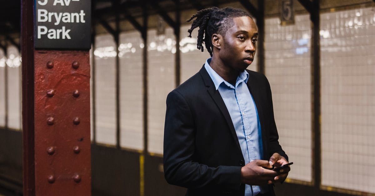 Using the Vatican City train station? - Confident male in office suit with mobile waiting for train Using the Vatican City train station? - Confident male in office suit with mobile waiting for train