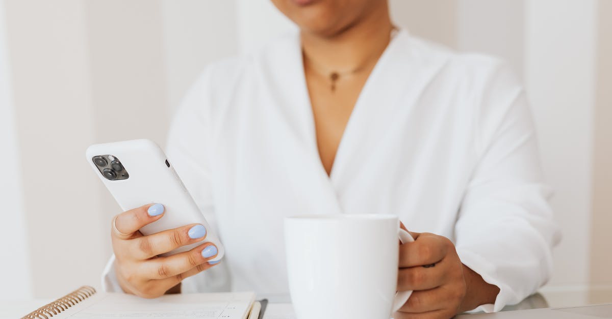 Using US iPhone 6 in Europe - Person in White Top Holding White Ceramic Mug while Using Cellphone Using US iPhone 6 in Europe - Person in White Top Holding White Ceramic Mug while Using Cellphone
