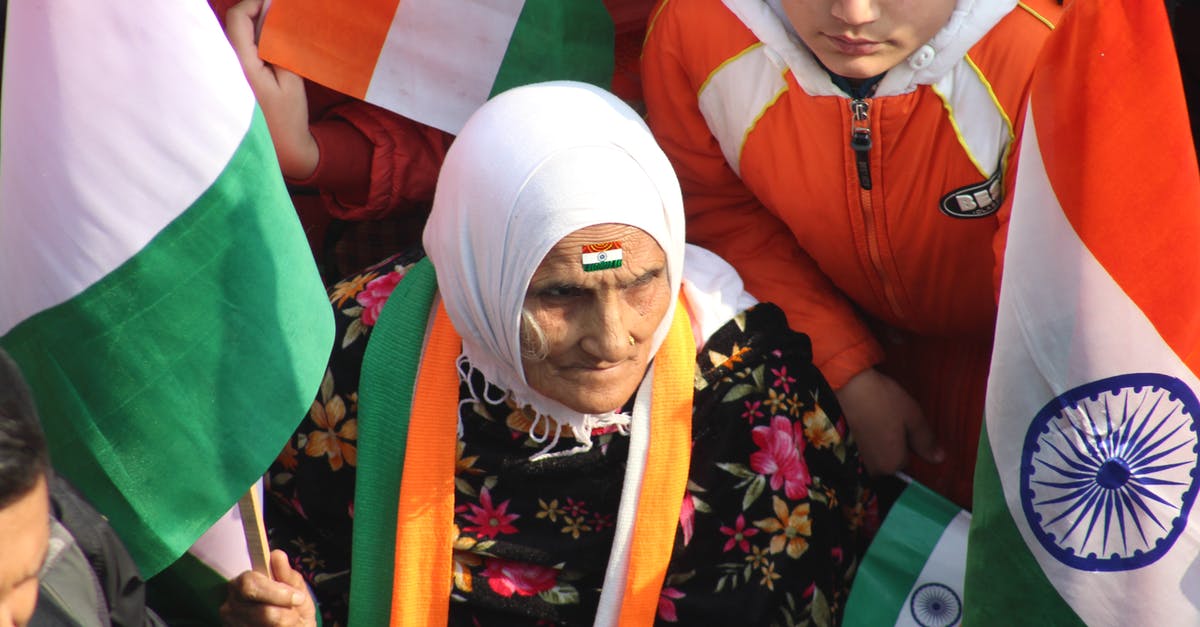 Validity of Czech Republic visa when Indian passport is re-issued - An Elderly Woman Sitting With A Group of People While Holding A Flag Validity of Czech Republic visa when Indian passport is re-issued - An Elderly Woman Sitting With A Group of People While Holding A Flag
