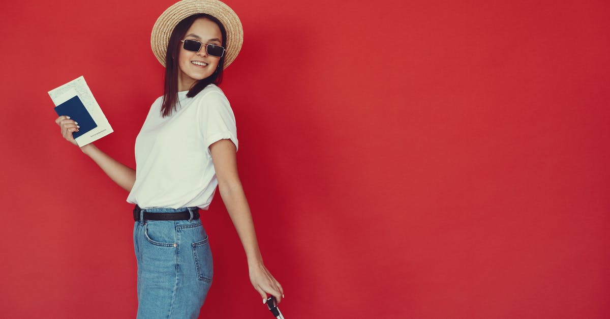 Validity of UK passport required to visit Italy - Smiling young female with luggage and passport on red background Validity of UK passport required to visit Italy - Smiling young female with luggage and passport on red background