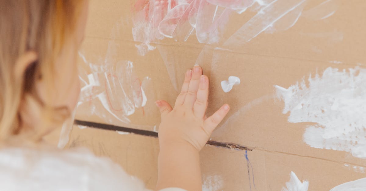 Vancouver YVR getting to quarantine with toddler - Crop anonymous child drawing with white paint at home Vancouver YVR getting to quarantine with toddler - Crop anonymous child drawing with white paint at home