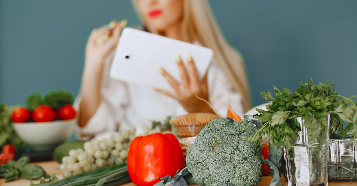 Vegetarian food in Morocco - Studio Shot of Vegetables on Table and Woman with Tablet in Background Vegetarian food in Morocco - Studio Shot of Vegetables on Table and Woman with Tablet in Background