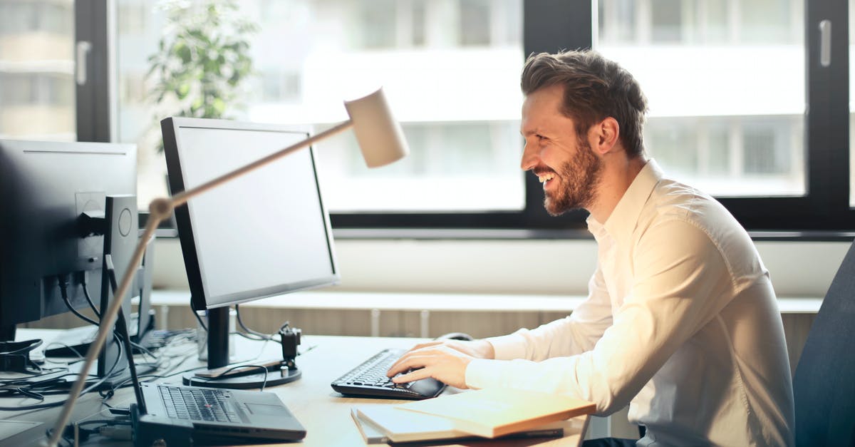 VFS not responding to email - Man in White Dress Shirt Sitting on Black Rolling Chair While Facing Black Computer Set and Smiling VFS not responding to email - Man in White Dress Shirt Sitting on Black Rolling Chair While Facing Black Computer Set and Smiling