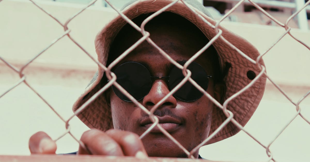 Vietnamese hat lost passing Security at DXB - 2nd March,2016 [closed] - Photo of a man wearing black sunglasses standing behind a chain link fence