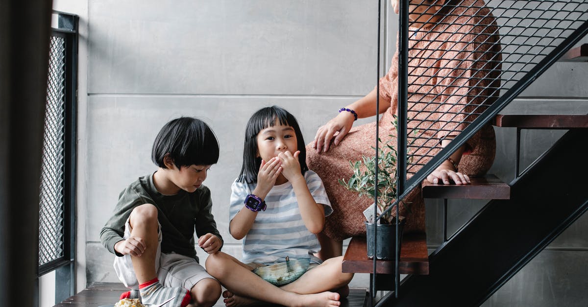 Visa restrictions while travelling with step children - Senior ethnic woman with grandchildren relaxing on stairway at home Visa restrictions while travelling with step children - Senior ethnic woman with grandchildren relaxing on stairway at home