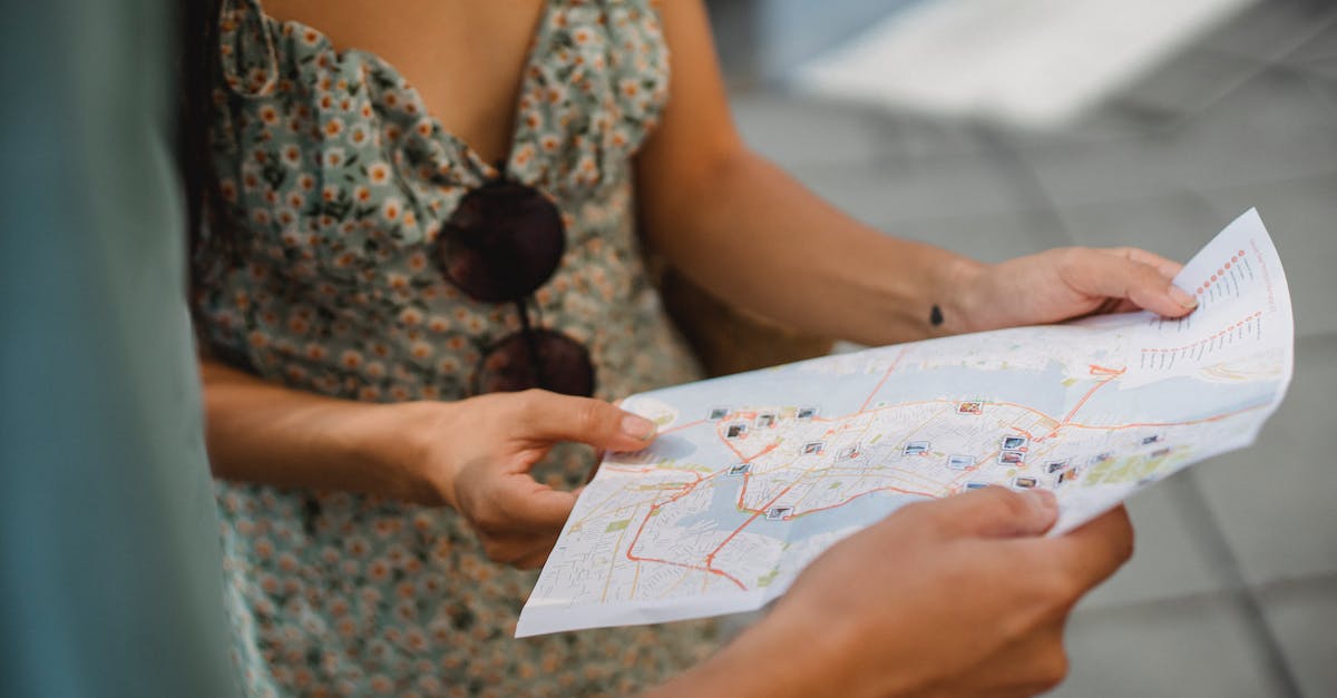 Visit the UK with Schengen tourist short-stay visa - Crop anonymous couple travelers in summer clothes checking location in paper map while walking in unknown city Visit the UK with Schengen tourist short-stay visa - Crop anonymous couple travelers in summer clothes checking location in paper map while walking in unknown city
